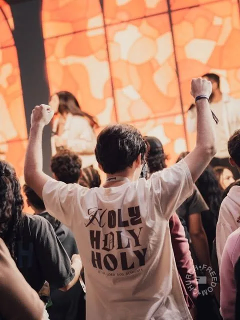 Jovem com a camiseta Holy Holy Holy da Freedom Store durante o culto